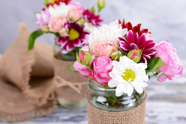 Beautiful bouquet of bright flowers in jars — Stock Photo, Image