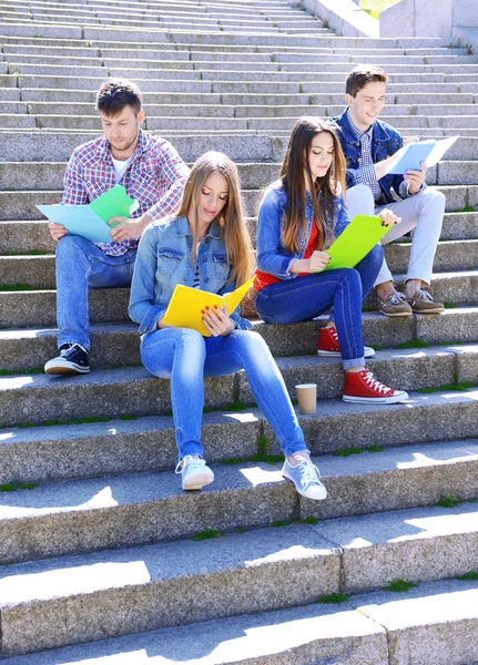 Students sitting on stairs in park — Stock Photo, Image