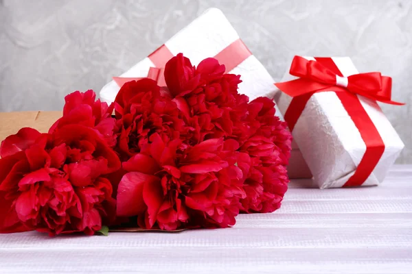 Beautiful pink peonies and gifts — Stock Photo, Image