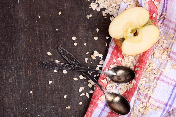 Apple with oatmeal and vintage spoons on napkin — Stock Photo, Image