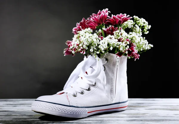 Vackra joggingskor med blommor inne — Stockfoto