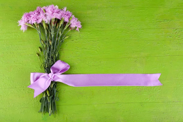 Beautiful bouquet with ribbon on wooden background — Stock Photo, Image