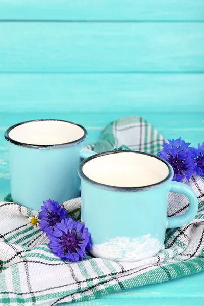 ミルクと木製のテーブルのヤグルマギクのカップ — ストック写真