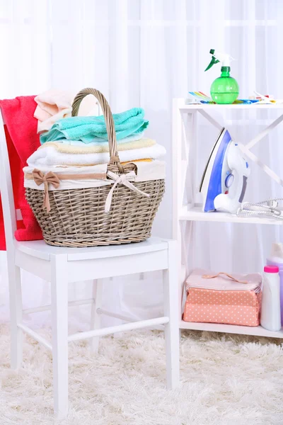 Colorful towels in basket on chair — Stock Photo, Image