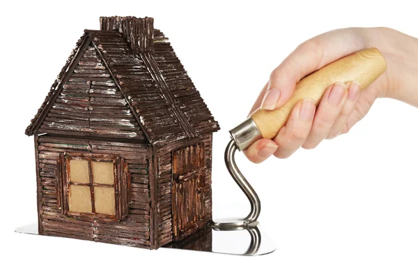Hand som håller trä leksak hus på murslev — Stockfoto