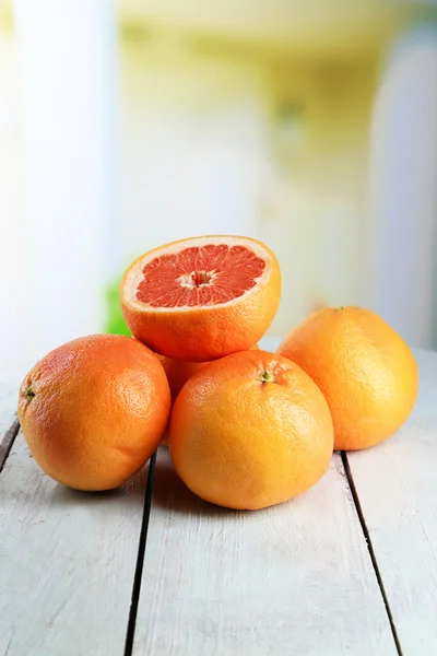 Zralých grapefruitů na dřevěné desce, na světlé pozadí — Stock fotografie