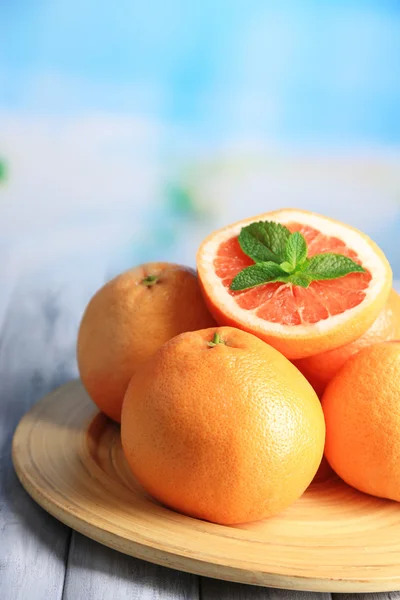 Mogen grapefrukt på träbord, på ljus bakgrund — Stockfoto