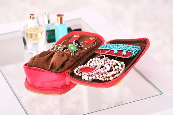 Handbag with accessorises and perfumes in bottles on table — Stock Photo, Image