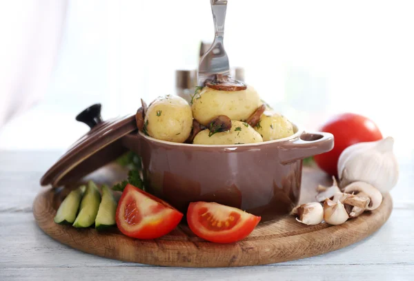 Jeunes pommes de terre bouillies dans une casserole avec légumes sur la table dans la cuisine — Photo