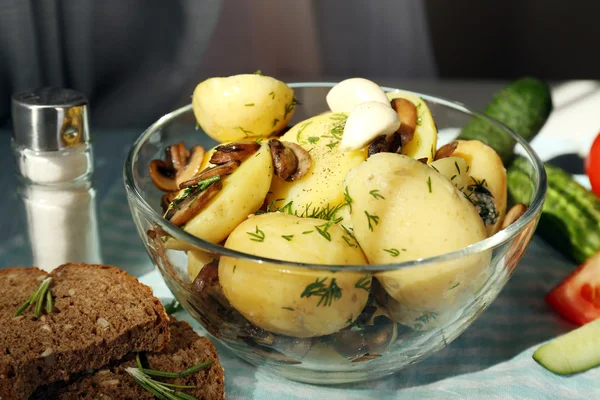 Mladí vařené brambory v míse na dřevěný stůl, zblízka — Stock fotografie
