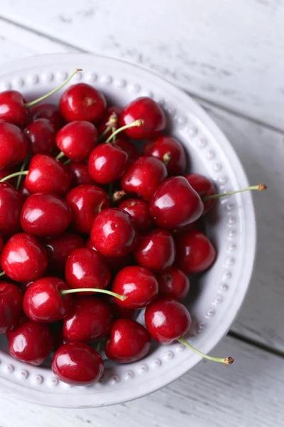 Sweet cherries in bowl on wooden background — Stock Photo, Image