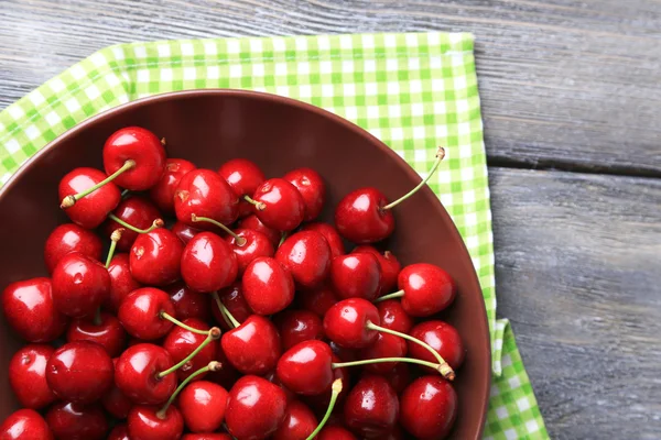 Cerezas dulces en plato sobre fondo de madera — Foto de Stock