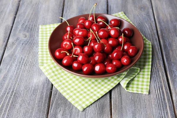 Sweet cherries  on plate on wooden background — Stock Photo, Image