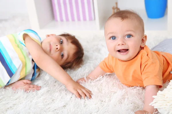Lindos niños mintiendo en la alfombra —  Fotos de Stock