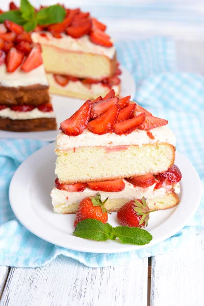 Delicious biscuit cake with strawberries on table — Stock Photo, Image
