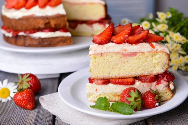 Delicious biscuit cake with strawberries on table — Stock Photo, Image