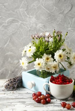 Masanın üzerinde çiçekler ve meyve ile natürmort