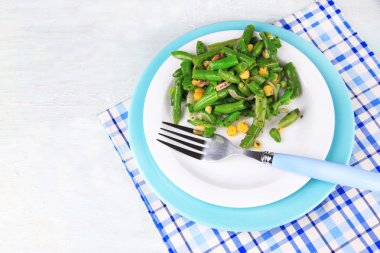 yeşil fasulye, jambon ve plaka renk ahşap zemin üzerine mısır salatası