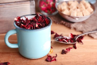 kurutulmuş hibiscus çay rengi kupa, kahverengi şeker kutusu ahşap zemin üzerinde