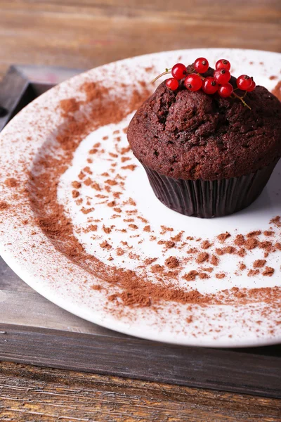 Čokoládový muffin s červeného rybízu na štítku na dřevěné pozadí — Stock fotografie