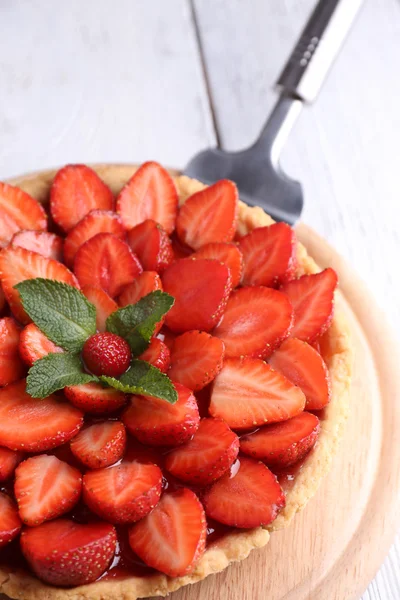 Tarte aux fraises sur plateau en bois, sur fond en bois couleur — Photo