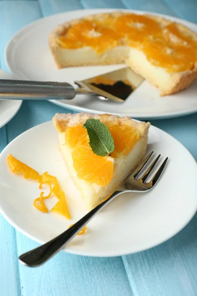 Pedaço de torta de laranja caseira na placa, na cor de fundo de madeira — Fotografia de Stock