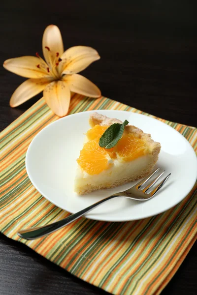 Pedaço de torta de laranja caseira na placa, na cor de fundo de madeira — Fotografia de Stock