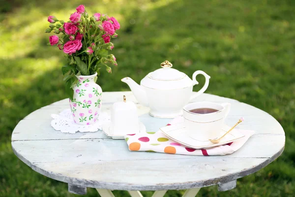 Teekanne und Tasse auf dem Tisch, Nahaufnahme, im Garten — Stockfoto