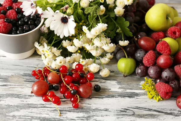 Blumen und Beeren auf Holztisch — Stockfoto