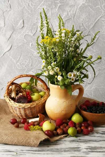 Martwa natura z kwiatami i jagody na drewnianym stole — Zdjęcie stockowe