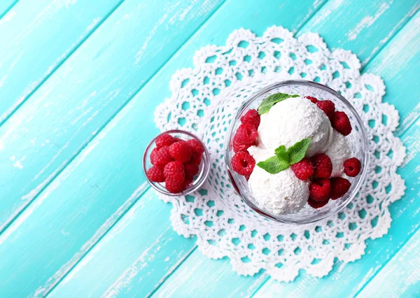 Crème glacée crémeuse aux framboises sur assiette dans un bol en verre, sur fond de bois couleur — Photo