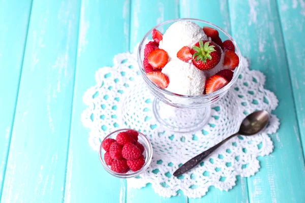 Helado cremoso con frambuesas en plato en cuenco de vidrio, sobre fondo de madera de color —  Fotos de Stock