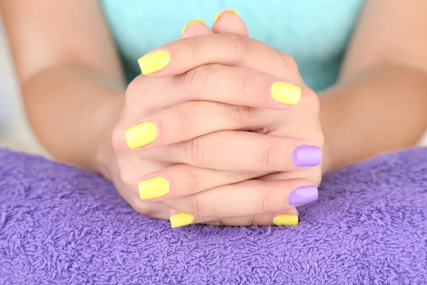 Kvinnlig hand med eleganta färgstarka naglar, på färg handduk, närbild — Stockfoto