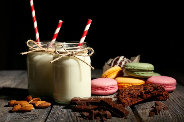 Leche en botellas con paja de papel sobre la mesa — Foto de Stock