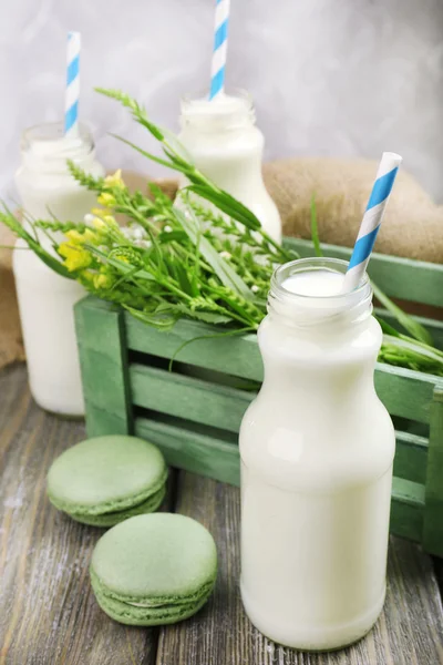 Milk in bottles with paper straws on table — Stock Photo, Image