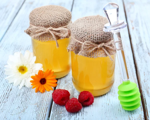 Kruik vol met heerlijke verse honing en wilde bloemen op houten tafel — Stockfoto