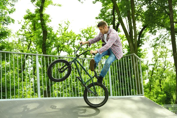 Мальчик прыгает на велосипеде BMX в скейт-парке — стоковое фото