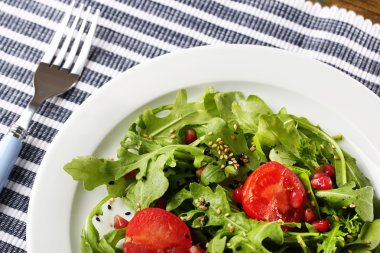 roka, domates ve susam ahşap zemin üzerinde plaka üzerinde yapılmış yeşil salata