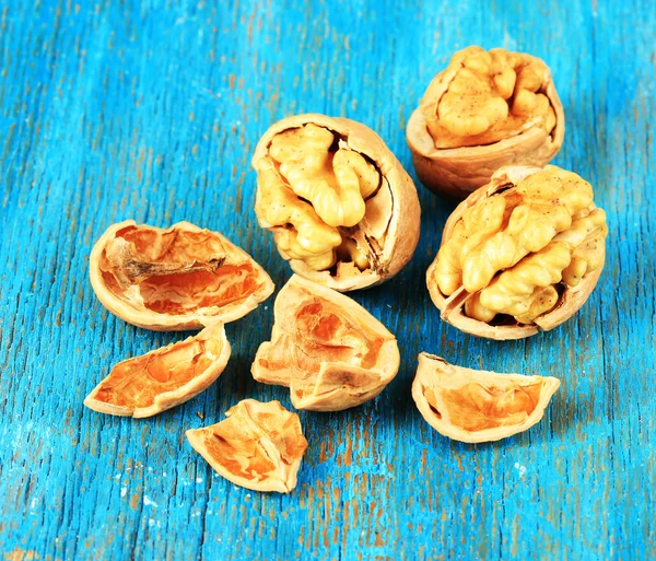 Broken walnuts on wooden table close-up — Stock Photo, Image