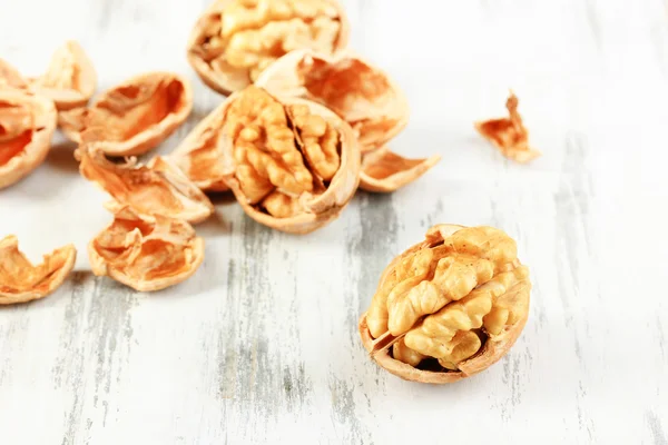 Broken walnuts on wooden table close-up — Stock Photo, Image