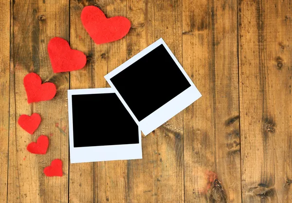 Fotos antiguas en blanco y corazones decorativos sobre fondo de madera de color — Foto de Stock