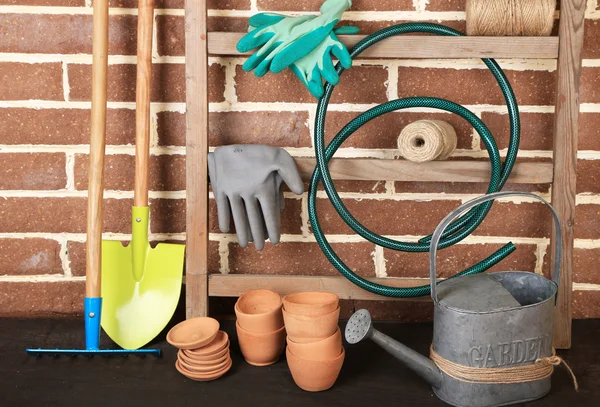 Herramientas de jardinero sobre fondo de ladrillos — Foto de Stock