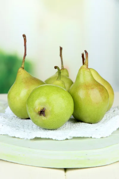 Pears on wooden cutting board, on light background Stock Photo