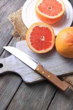 Olgun greyfurt ve kesme tahtası üzerinde bıçak