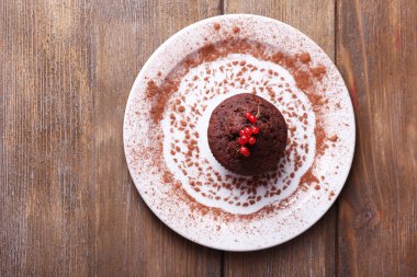 plaka üzerinde ahşap arka plan üzerinde kırmızı kuş üzümü ile çikolatalı kek