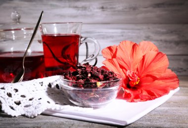 Hibiscus çay cam çaydanlık ve ahşap arka plan üzerinde renkli peçete çiçek