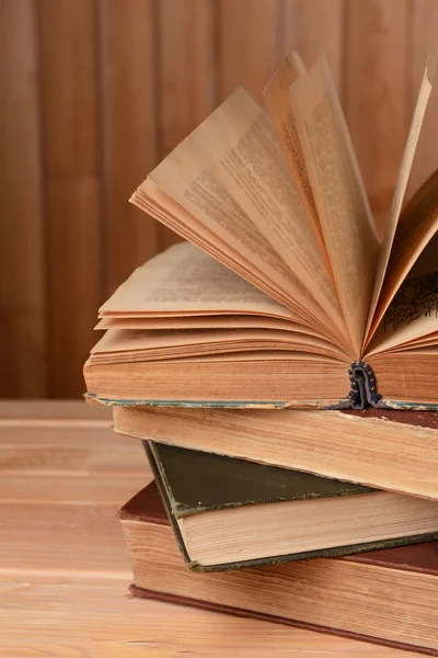 Livros antigos na mesa sobre fundo de madeira — Fotografia de Stock