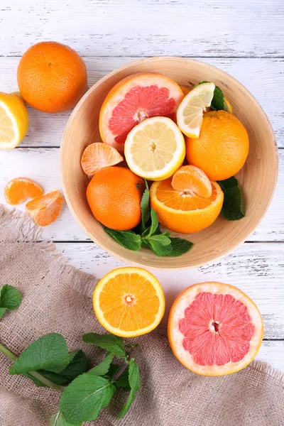 Verse citrusvruchten met groene bladeren in kom — Stockfoto