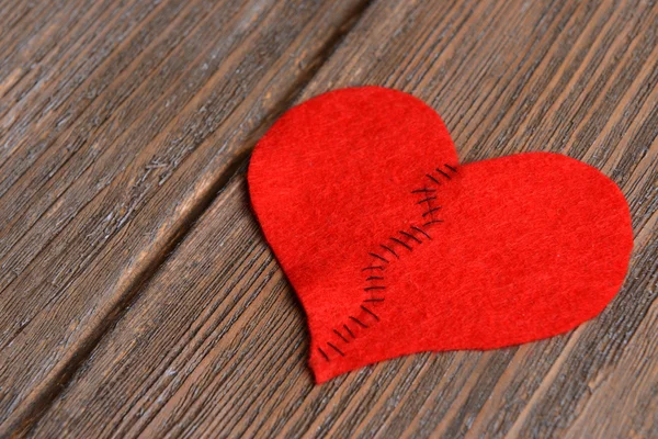 Broken heart and thread on wooden background — Stock Photo, Image