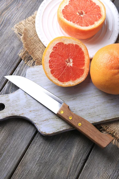 Olgun greyfurt ve kesme tahtası üzerinde bıçak